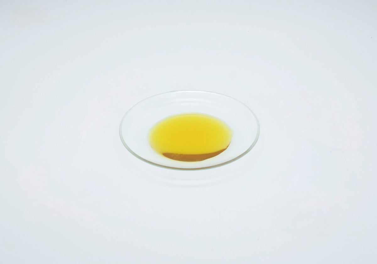 Golden yellow unrefined Red Raspberry Seed Oil in a clear glass dish.