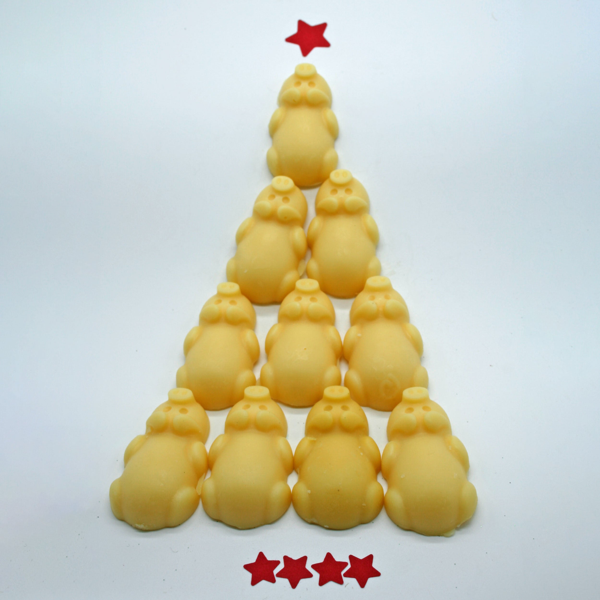 Berry Beautiful Piggie Moisturizing Bars arranged in a pyramid shape like a Christmas tree, topped with a red star and accented with four red stars at the base for a festive display.